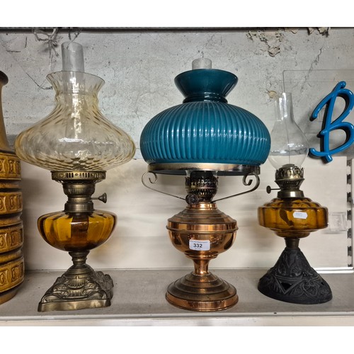 332 - Three oil lamps. Two with coloured glass bowls, all with funnels, 2 with glass shades