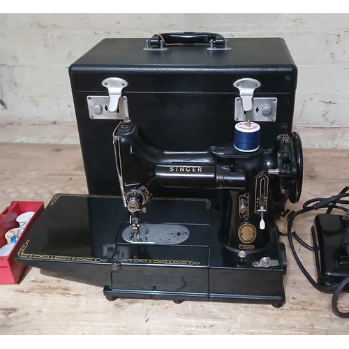 A Singer Featherweight 222K sewing machine, boxed with accessories.