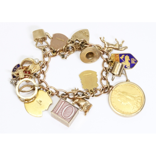 121 - A 9ct gold charm bracelet, the majority of the charms hallmarked 9ct gold, including an 1888 soverei... 