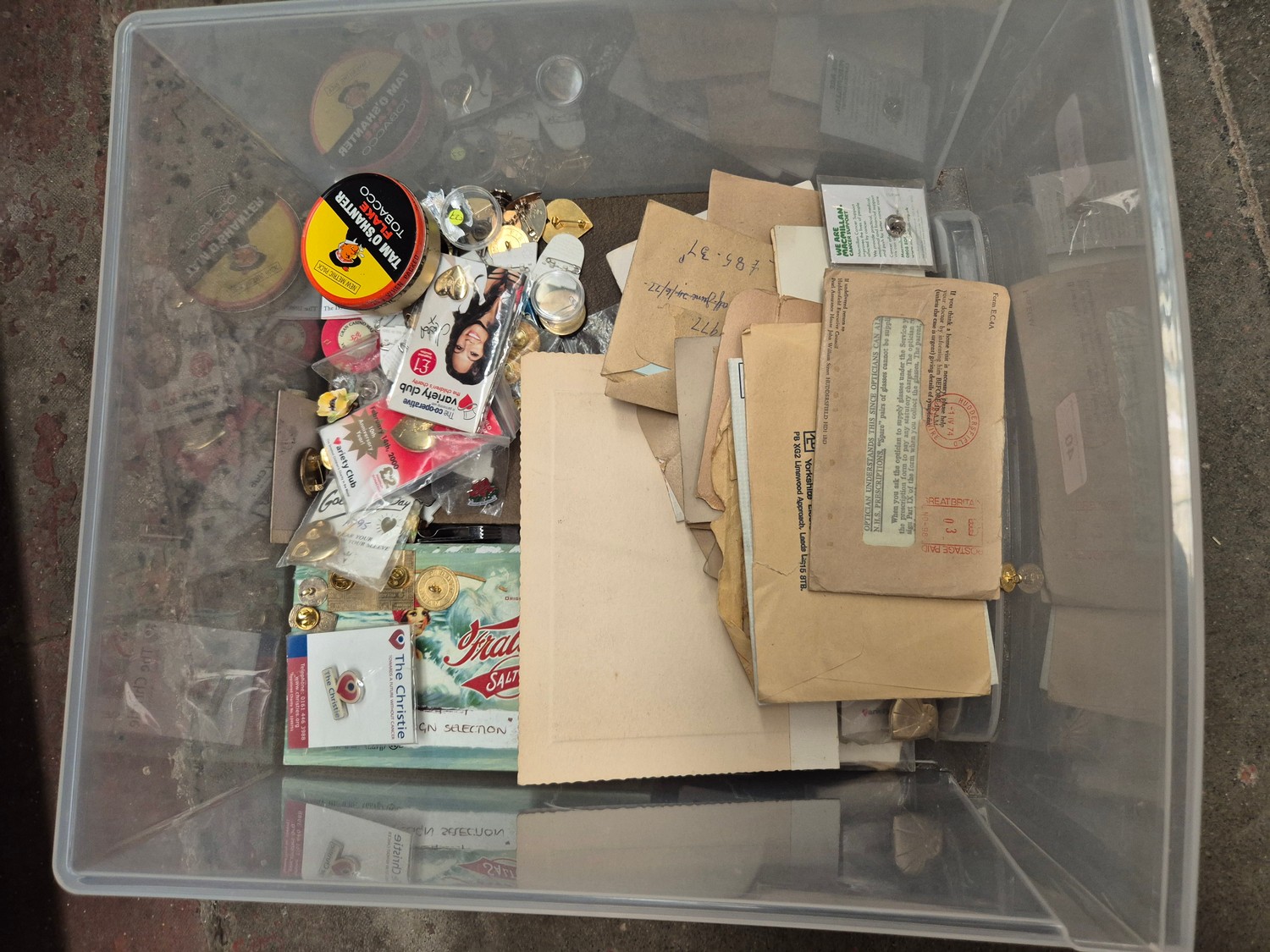 A box of assorted collectables to include postcards, badges & ephemera etc.