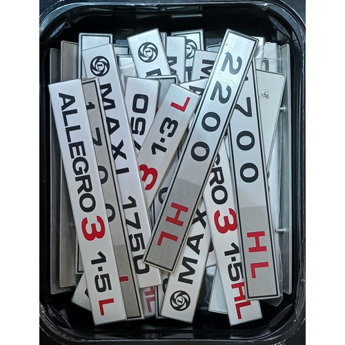 185 - A box of assorted classic car badges.