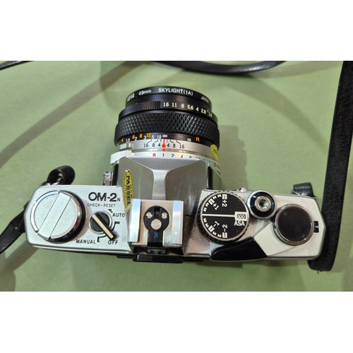 An Olympus OM2 35mm camera and an Canon EOS 5000.