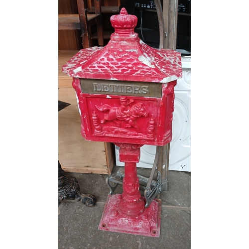697 - A cast metal post box and a brass fender.