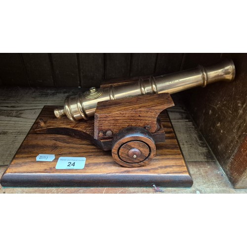 24 - A brass signal cannon mounted on a wooden base