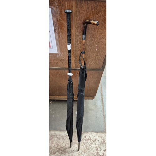 294 - A ladies black parasol with carved handle, together with a black umbrella with tortoise shell handle... 