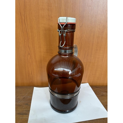 152 - Vintage Amber Glass 2Lt Wine Bottle with Metal Handle and Porcelain Lid (35cm H.)