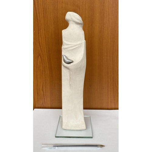 16 - Ceramic Woman's Figure Holding Bird on Glass Base Signed 'DR' in Greek (30cm H.)