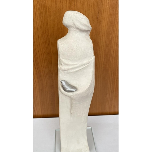 16 - Ceramic Woman's Figure Holding Bird on Glass Base Signed 'DR' in Greek (30cm H.)