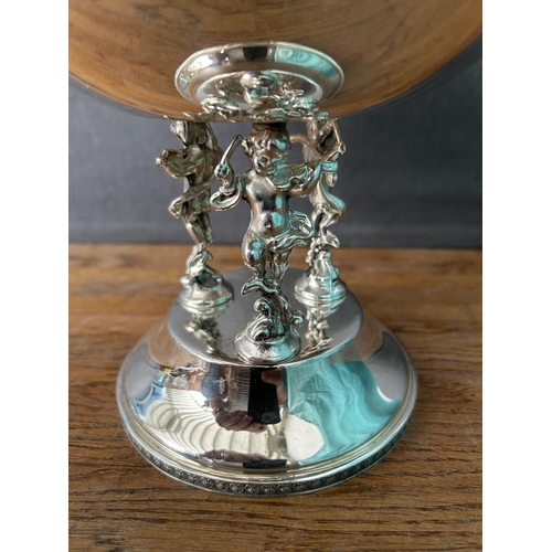 191 - Italian Silver Plated Center Piece Bowl Sitting on 3-Cherub Figures (30cm H., 20cm Diameter)