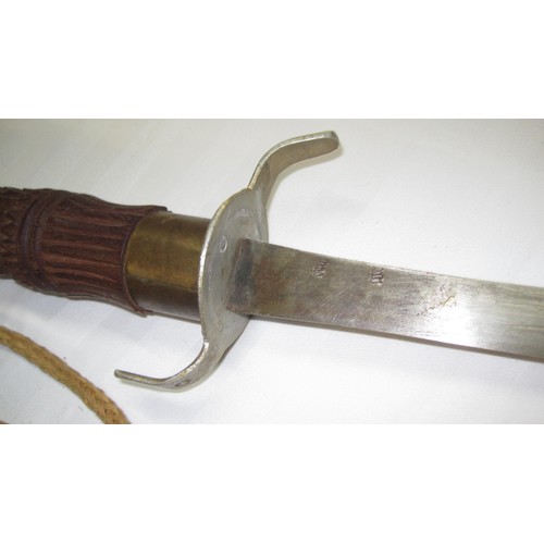 141 - An interesting Asiatic sword in an ornately carved wooden scabbard