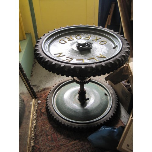 322 - A coffee table made from a pair of cast agricultural wheels and axle, in good order