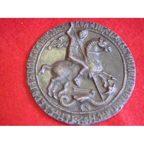 60 - A vintage coin or token featuring St George killing the dragon to one side, surrounded by possibly c... 