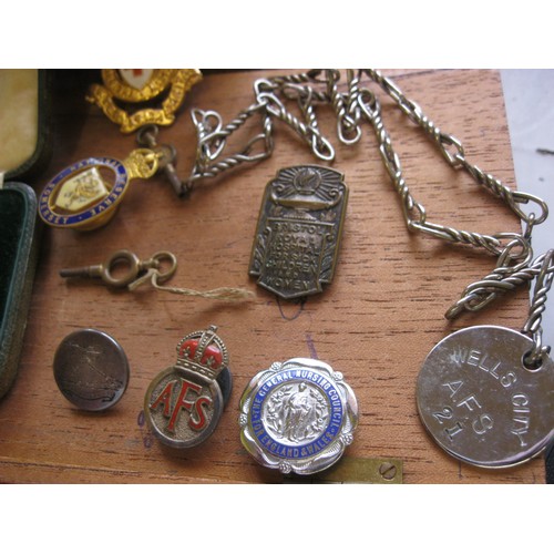 135A - A small wooden box containing various RNR buttons, Auxiliary Fire Service badges and ID tags, Somers... 