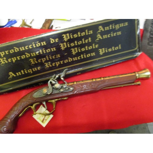 215 - A Spanish-made replica flintlock pistol with a bell muzzle, boxed, working mechanism, some damp dama... 