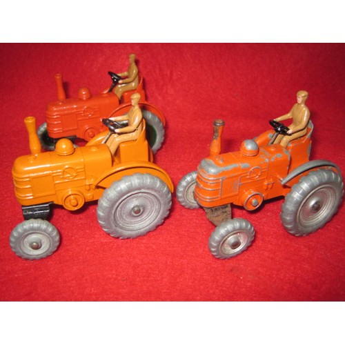 166 - 3 Dinky Massey tractors 2 good condition 1 fair playworn all with drivers and steering wheels 2 oran... 