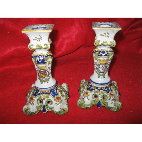 49 - A pair of porcelain candlesticks with painted crests