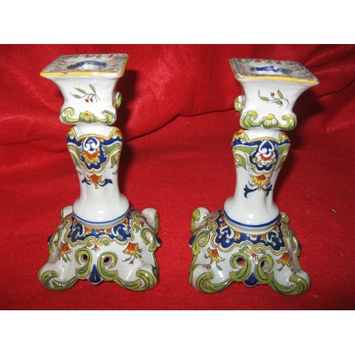 49 - A pair of porcelain candlesticks with painted crests