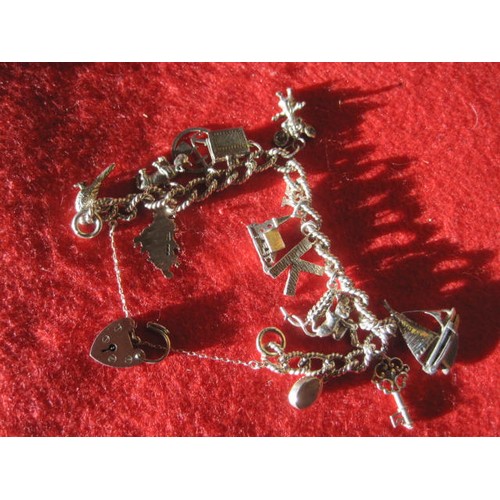 106 - A sterling silver charm bracelet with 14 silver charms attached, all in good order, total approximat... 