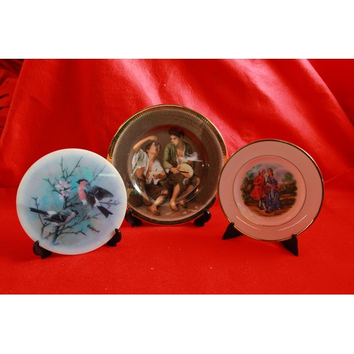 66 - A large tray of Royal Doulton pictures plates, most boxed, plus a bag of plate stands etc