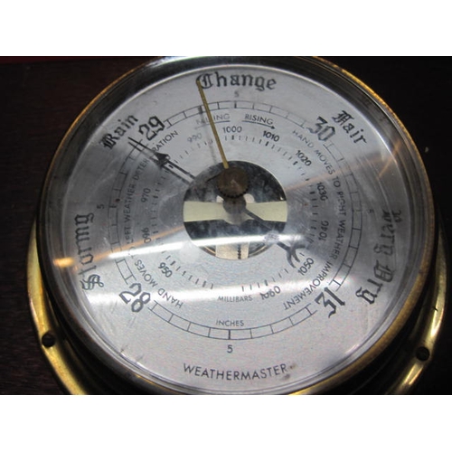 140 - A bulkhead-style brass cased quartz clock and a matching brass cased Weathermaster barometer both mo... 