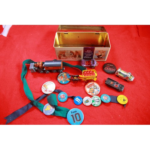 54 - A tin box containing a mixture of diecast toy cars and old pin badges