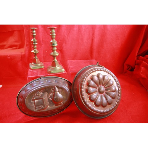 16 - Two large copper jelly moulds and a pair of cast brass candlesticks, all in good order