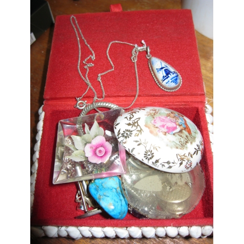 82 - A small jewellery/trinket box decorated with shells containing an assortment of jewellery and brooch... 