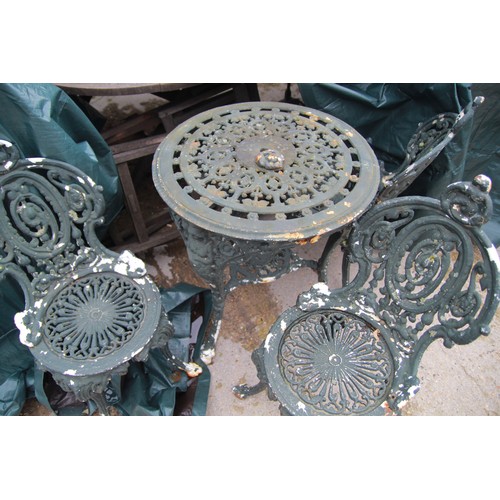 113 - A heavy cast metal garden set comprising a round table and three chairs