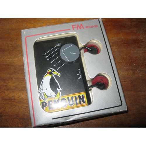 182 - A Penguin Biscuits branded pocket radio with headphones, boxed and unused.