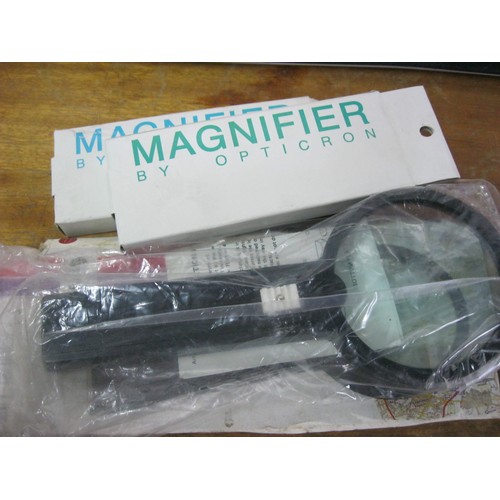 376 - A pair of new and boxed magnifying glasses by Opticron and a larger Magnifier-Lite