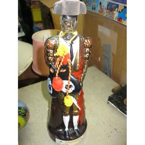 406 - A vintage (full) bottle of Sangria in the form of a bullfighter with a pair of castanets around his ... 