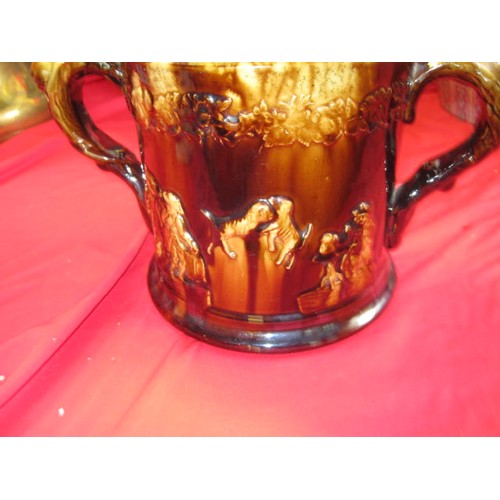 93 - A treacle ware two handled loving cup with internal frogs approx nine inches across by 6 high