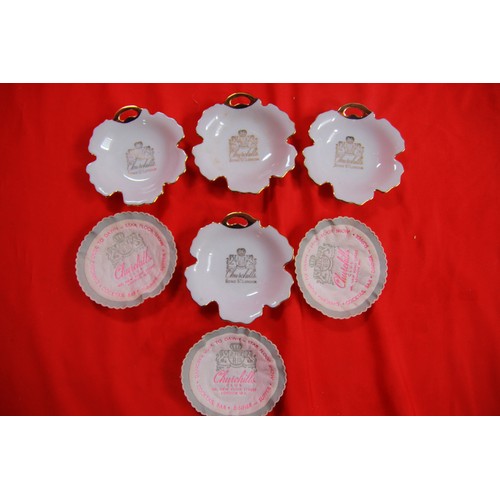 213 - A small leather holder marked Churchill's Club, Bond Street, London containing 4 ashtrays/pin dishes... 