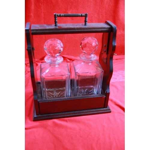 24 - A vintage Tantalus with keys and decanters, in good order