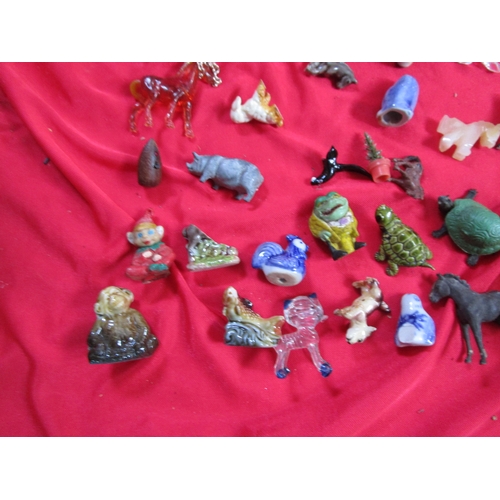 213 - A selection of Glass and porcelain figurines including a selection of Wade animals and some early pl... 