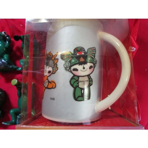 215 - 2008 Olympic mug fully boxed with original carry bag, along with four green plastic frogs who appear... 