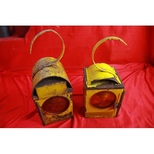 16 - A pair of vintage metal paraffin roadworks lamps in yellow, with burners and glass