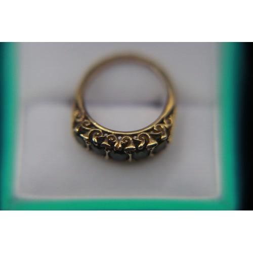 21 - A substantial 9 carat gold and green sapphire ring set with 5 stones in an ornate mount, approx weig... 