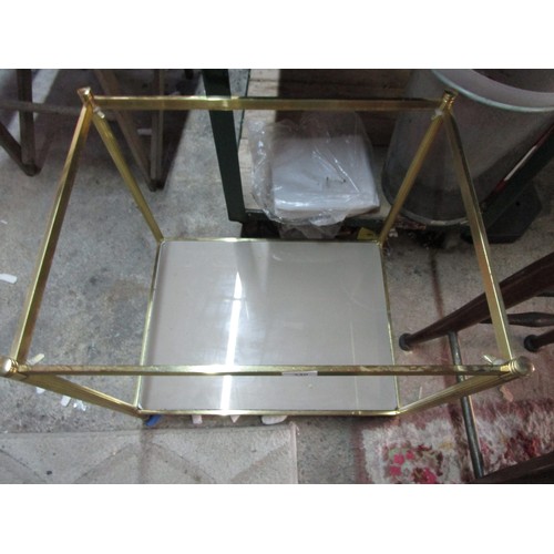 84 - A brass effect side table with smoked glass upper and lower shelves, in good order