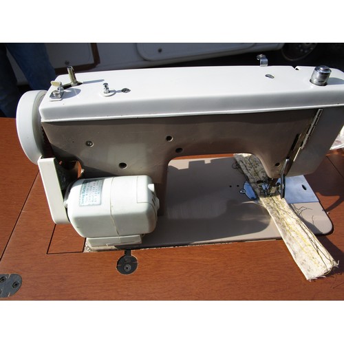 96 - An electric sewing machine built into a flip top table, and two other sewing machines