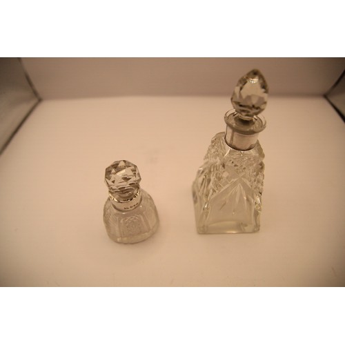 184 - A pair of ornate Victorian cut glass scent bottles with silver collars, the large marked 'Sterling S... 