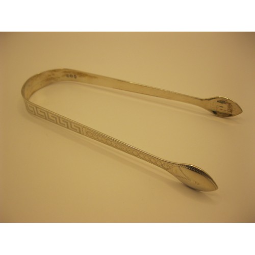 228 - A substantial pair of sugar tongs in sterling silver, embellished with Greek Key design to handle, h... 