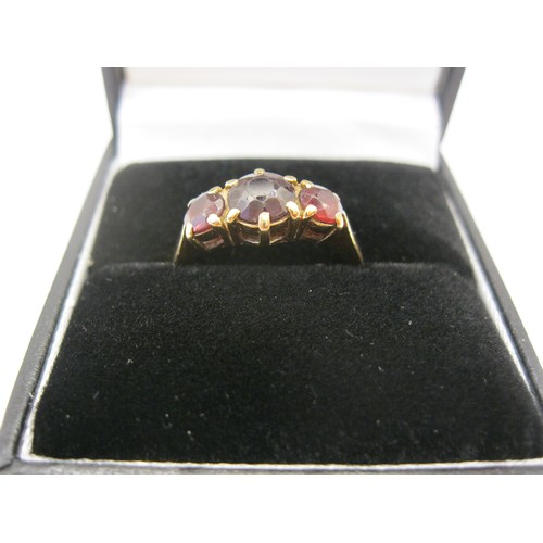 237 - A 9 carat gold ring set with three garnets, approx weight 2.8g, size O