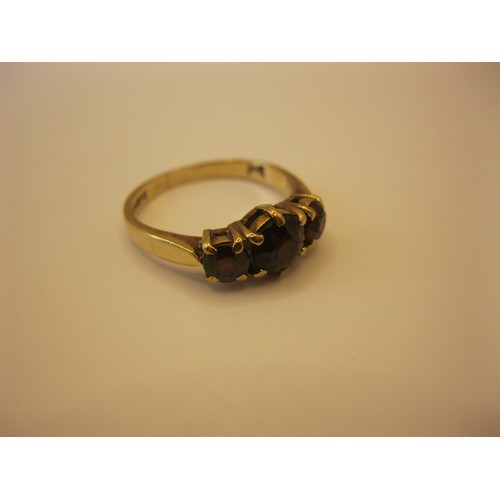 237 - A 9 carat gold ring set with three garnets, approx weight 2.8g, size O