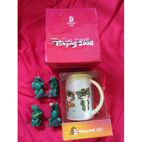 68 - 2008 Olympic mug fully boxed with original carry bag, along with four green plastic frogs who appear... 