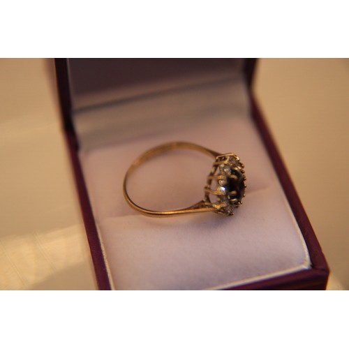 22 - A 9 carat gold ring with substantial central sapphire surrounded by a cluster of diamonds, approx we... 