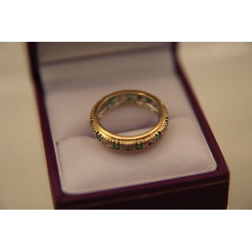 25 - A 9 carat gold eternity ring set with pale green stones, possibly emeralds, approx weight 2.7g, size... 