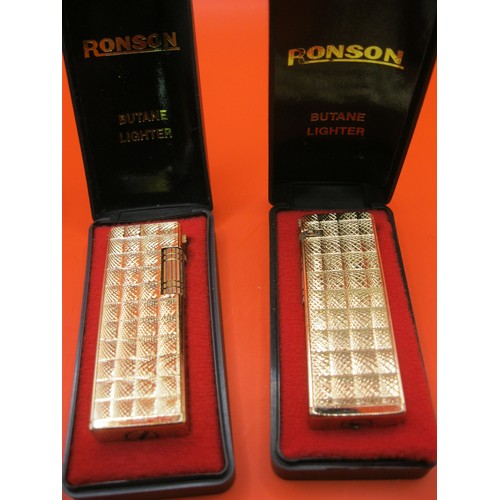 281 - A pair of Ronson gold-coloured metal lighters, appear unused, in original boxes - one marked KM275, ... 