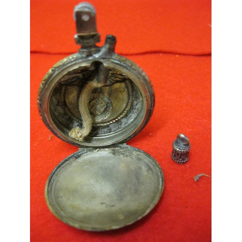 322 - A petrol lighter made from a pocket watch case, the exterior bearing the Parteiadler of the NSDAP ab... 