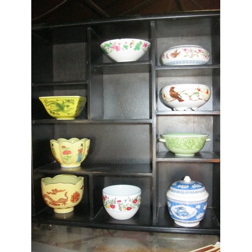 109 - A wooden display case containing porcelain bowls in an oriental style